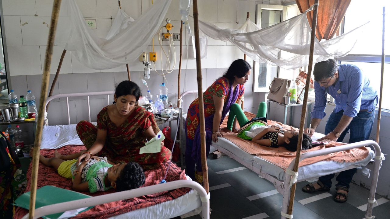 A doctor attends to dengue patients in a pediatric ward at New Delhi's Hindu Rao hospital. 