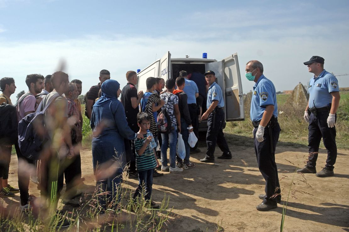 Croatian police officers round up migrants close to the Serbia-Croatia border in 2015.