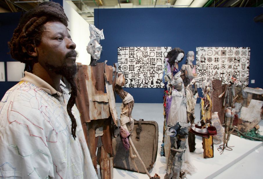 Nigerian artist Dilomprizulike poses near one of his pieces of art,  "Waiting for Bus' (2003), at the Centre Pompidou in Paris.