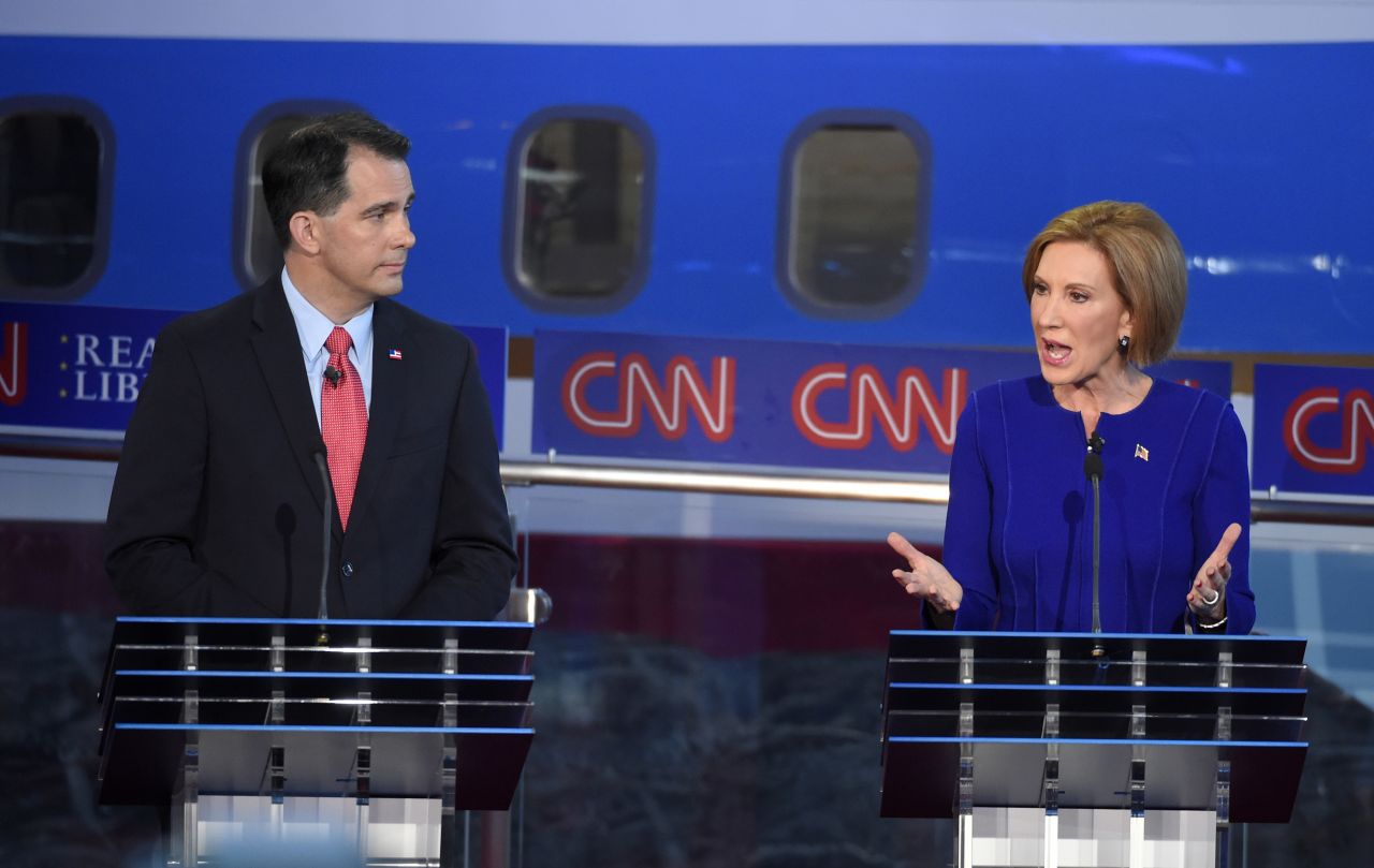 Walker watches Fiorina answer a question.