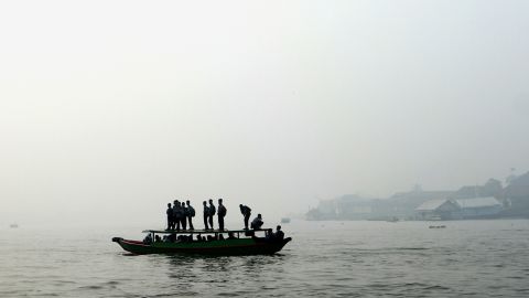 Students cross a river under a blanket of haze September 17 in Palembang, Indonesia.