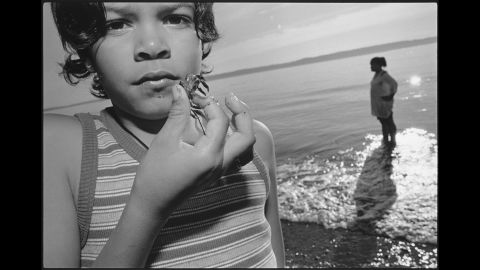 One of Tiny's children, Keanna, holds a baby crab at a beach in 1999.