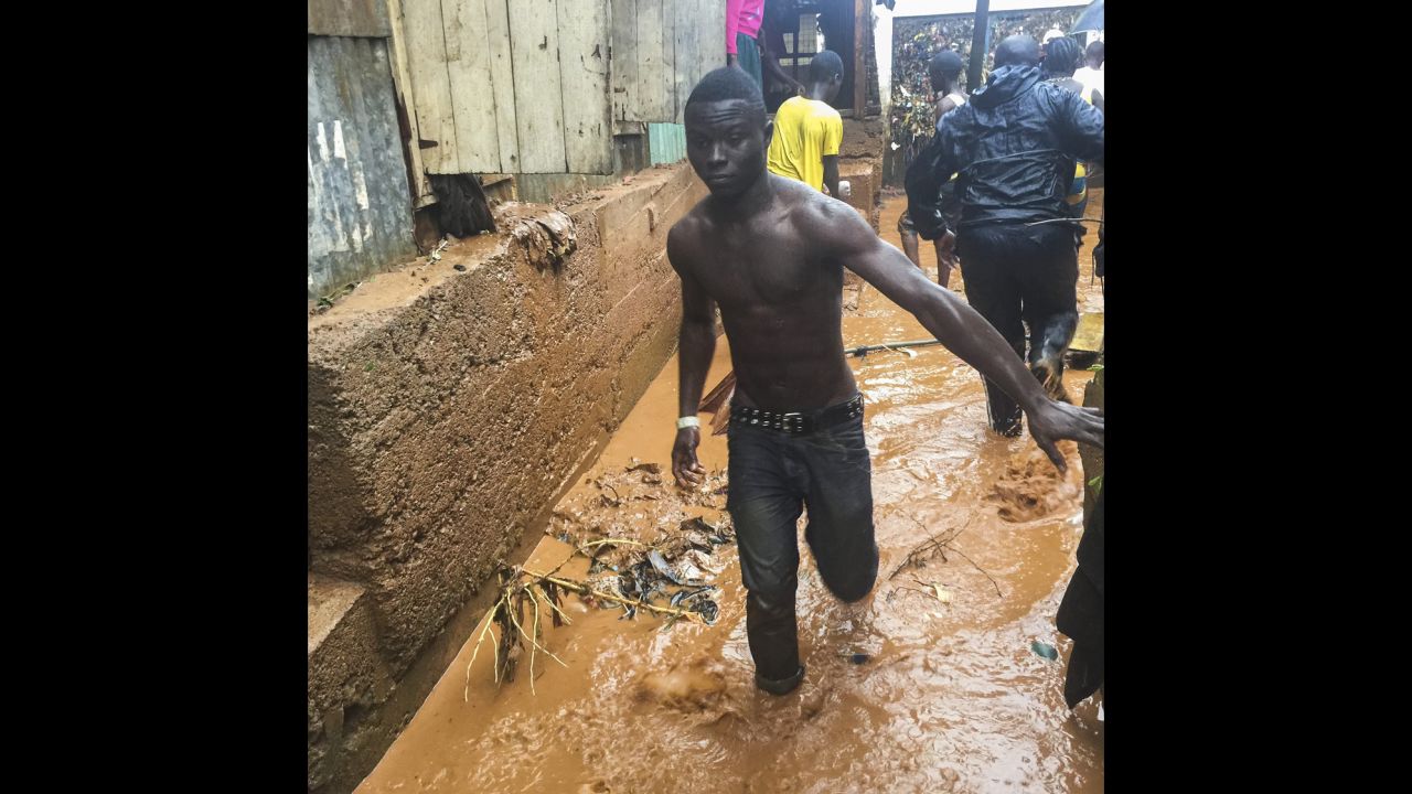 A man walks Thursday along a flooded street in Freetown, Sierra Leone, which has been drenched by days of heavy rain. 