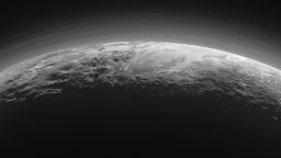 Just 15 minutes after its closest approach to Pluto on July 14, 2015, NASA's New Horizons spacecraft looked back toward the sun and captured this near-sunset view of the rugged, icy mountains and flat ice plains extending to Pluto's horizon. The smooth expanse of the informally named icy plain Sputnik Planum (right) is flanked to the west (left) by rugged mountains up to 11,000 feet (3,500 meters) high, including the informally named Norgay Montes in the foreground and Hillary Montes on the skyline. To the right, east of Sputnik, rougher terrain is cut by apparent glaciers. The backlighting highlights more than a dozen layers of haze in Pluto's tenuous but distended atmosphere. The image was taken from a distance of 11,000 miles (18,000 kilometers) to Pluto; the scene is 780 miles (1,250 kilometers) wide. 