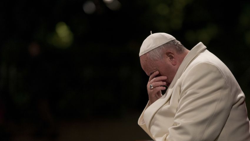 Pope Francis bows his heads during the Via Crucis (Way of the Cross) torchlight procession in Rome, Friday, April 18, 2014. Pope Francis presided over a torch-lit Way of the Cross procession at the Colosseum marking Good Friday in Rome. The pope's resolve to focus the Catholic church's attention on those who suffer was reflected in meditations read aloud to commemorate Jesus' crucifixion. (AP Photo/Alessandra Tarantino)