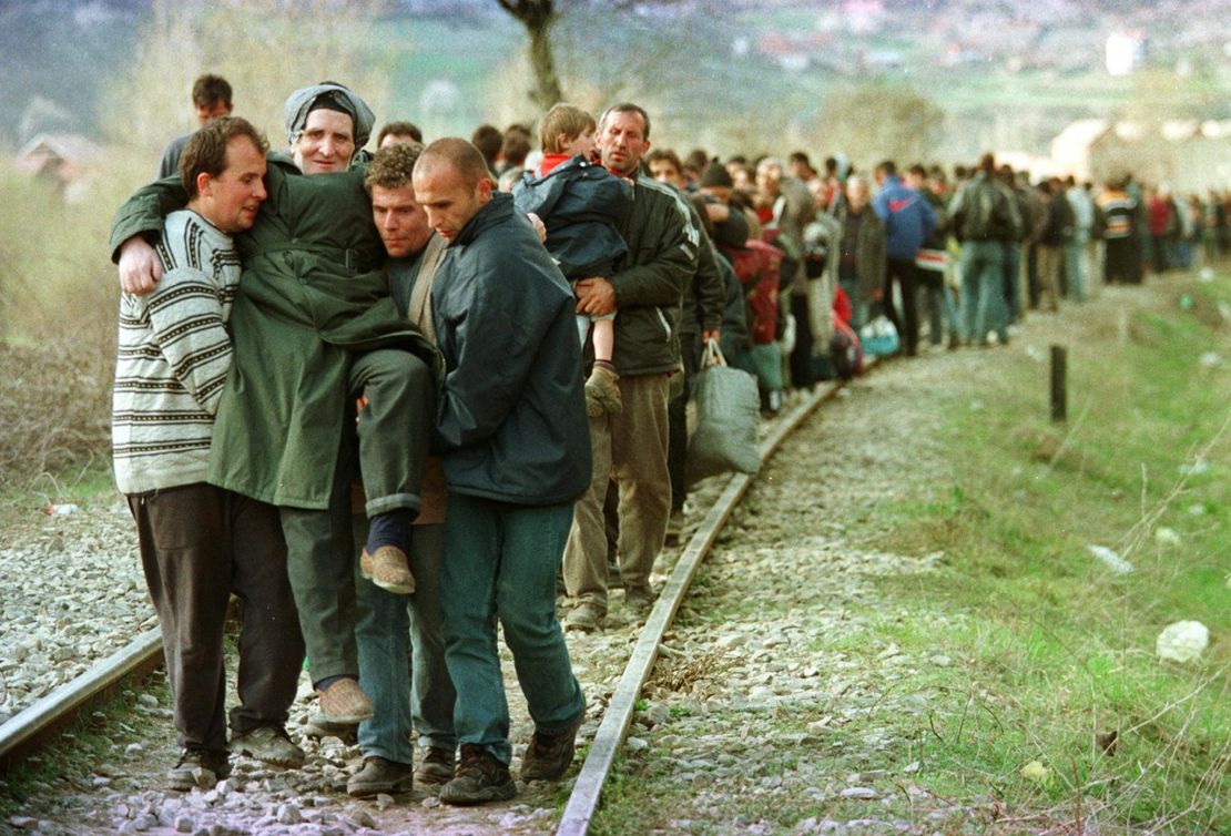 Ethnic Albanian refugees arrive by foot in Macedonia in April, 1999 after being forced off a train in Kosovo.