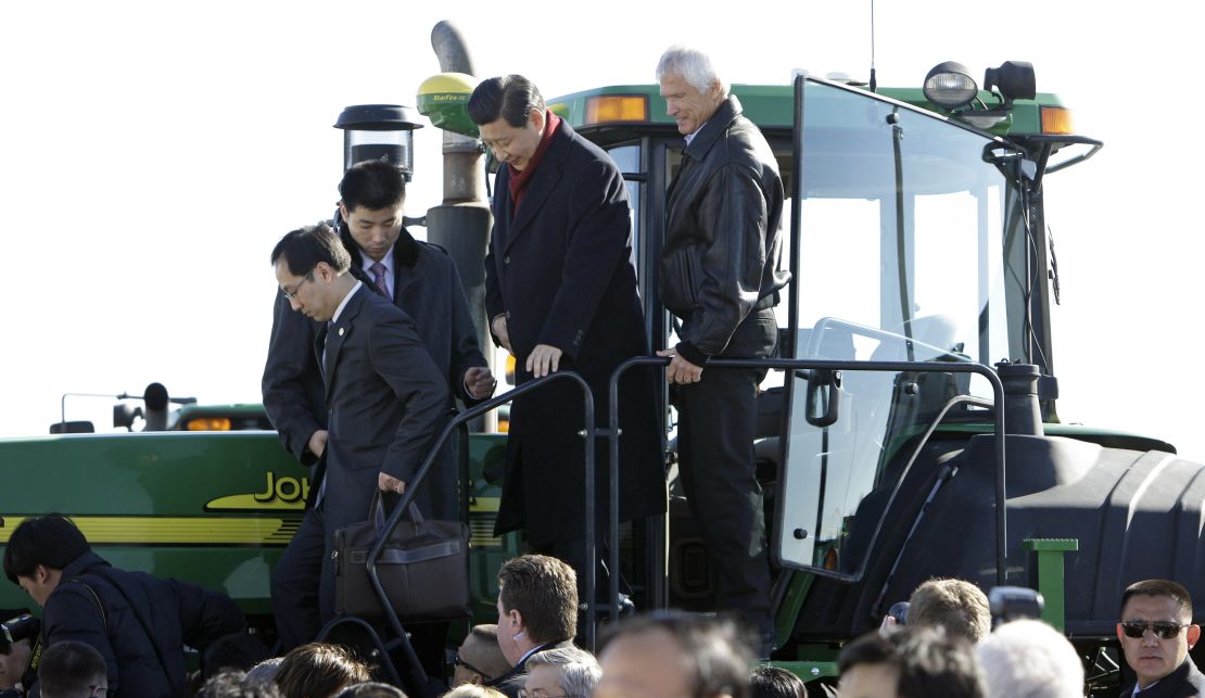 Then-Vice President Xi (2nd R) climbs out of the cab of a tractor with Rick Kimberley (R) while touring his family farm on February 16, 2012 in Maxwell, Iowa.