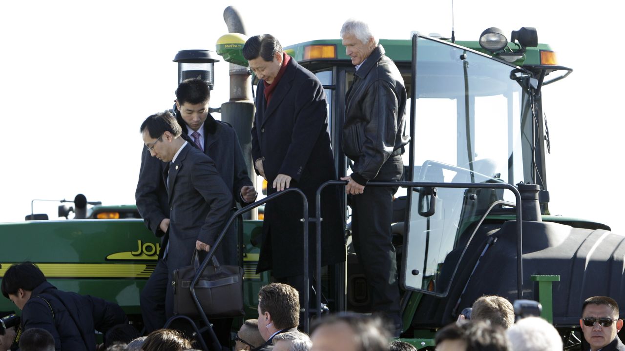 Then-Vice President Xi (2nd R) climbs out of the cab of a tractor with Rick Kimberley (R) while touring his family farm on February 16, 2012 in Maxwell, Iowa.