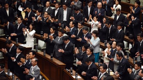 Councillors of the upper house applaud after the security bill passed the parliament on early September 19, 2015. The bill would allow troops to fight on foreign soil for the first time since World War II, despite fierce criticism it will fundamentally alter the character of the pacifist nation. AFP PHOTO / TOSHIFUMI KITAMURA (Photo credit should read TOSHIFUMI KITAMURA/AFP/Getty Images)