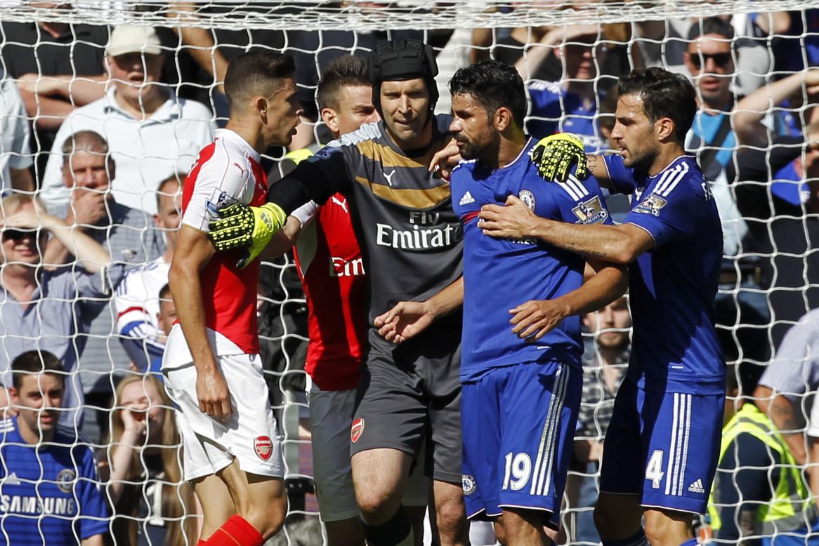 Costa's former Chelsea teammate Petr Cech tries to separate the two players. 