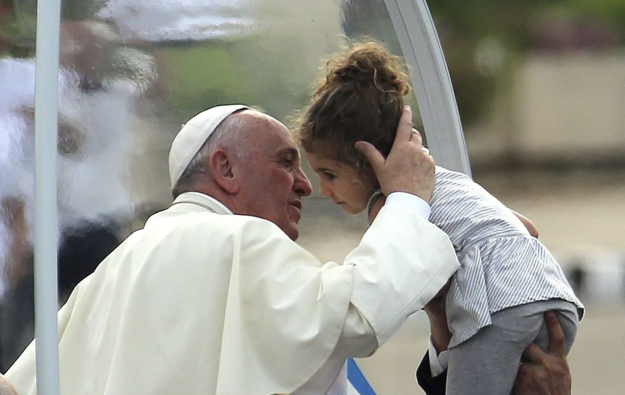 Pope Francis kisses a child as he arrives in Revolution Square on September 20. 