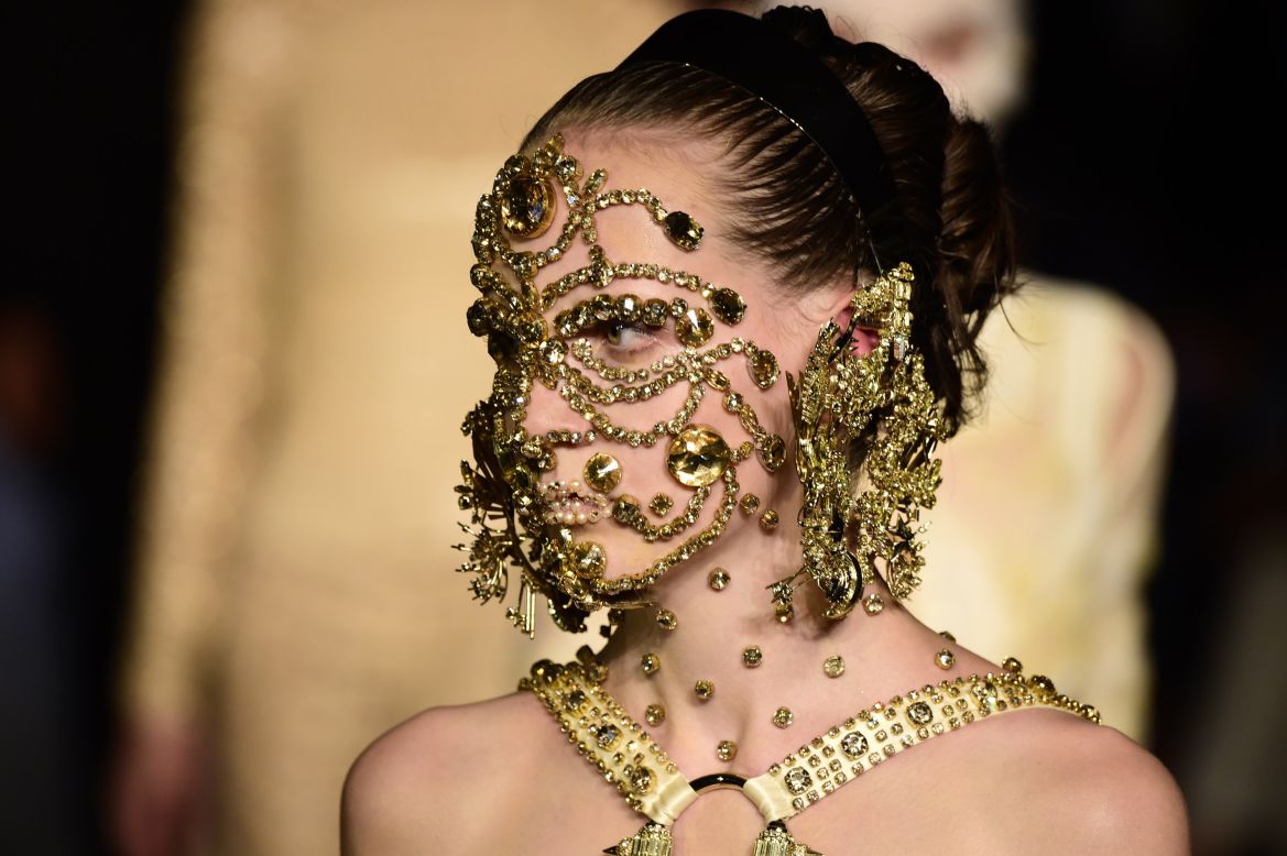 A model sporting a gold mask beauty look by visionary make up artist Pat McGrath. 