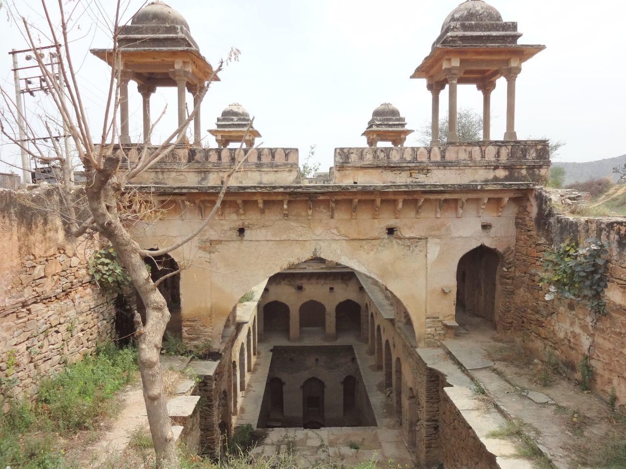 "It's not easy getting to this small stepwell in the fields outside the city of Narnaul, with its many spectacular Mughal monuments. But the dirt road eventually lead to pretty -- if overgrown -- stepwells, with its four chattris that come into view. What a peaceful spot in its day - I'm sorry this one's such a ruin."