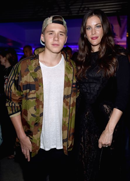 Brooklyn Beckham and Liv Tyler pose for a photo at the Givenchy after party. 