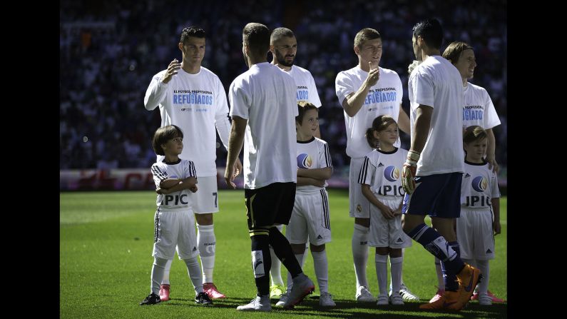 <a href="index.php?page=&url=http%3A%2F%2Fwww.cnn.com%2F2015%2F09%2F21%2Ffootball%2Fspain-ronaldo-syrian-migrant-boy%2F" target="_blank">A young Syrian refugee</a> named Zied, left, stands in front of Real Madrid superstar Cristiano Ronaldo prior to a Spanish league soccer match in Madrid on Saturday, September 19. Zied and his father, Osama Abdul Mohsen, were in the news earlier this month after a journalist tripped them as they fled a Hungarian holding camp.