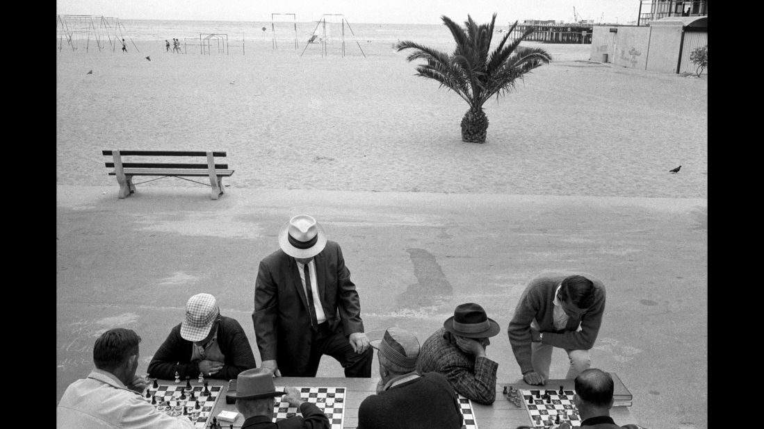 Men play chess near the beach.