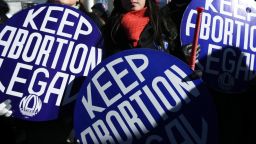 WASHINGTON, DC - Pro-choice activists hold signs as marchers of the annual March for Life arrive in front of the US Supreme Court January 22, 2014. Pro-life activists from all around the country gathered in Washington for the event to protest the Roe v. Wade Supreme Court decision in 1973 that helped to legalize abortion in the United States.  (Photo by Alex Wong/Getty Images)