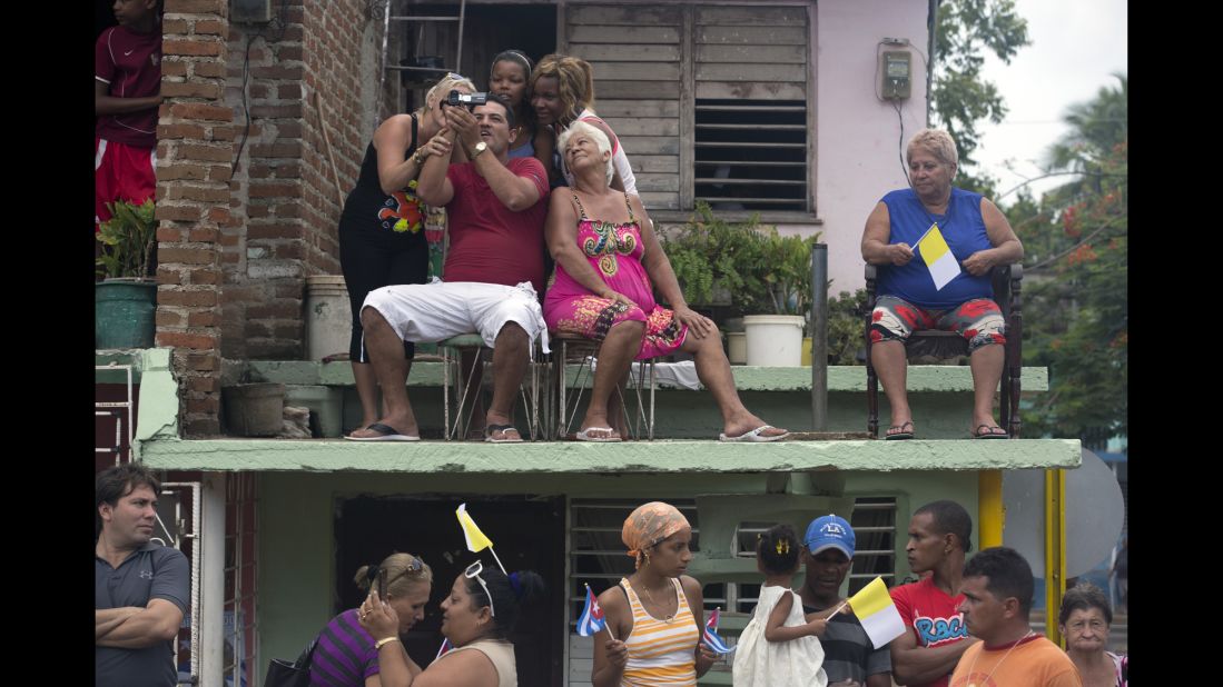 Residents wait for Pope Francis to drive past in Holguin, Cuba, on September 21.