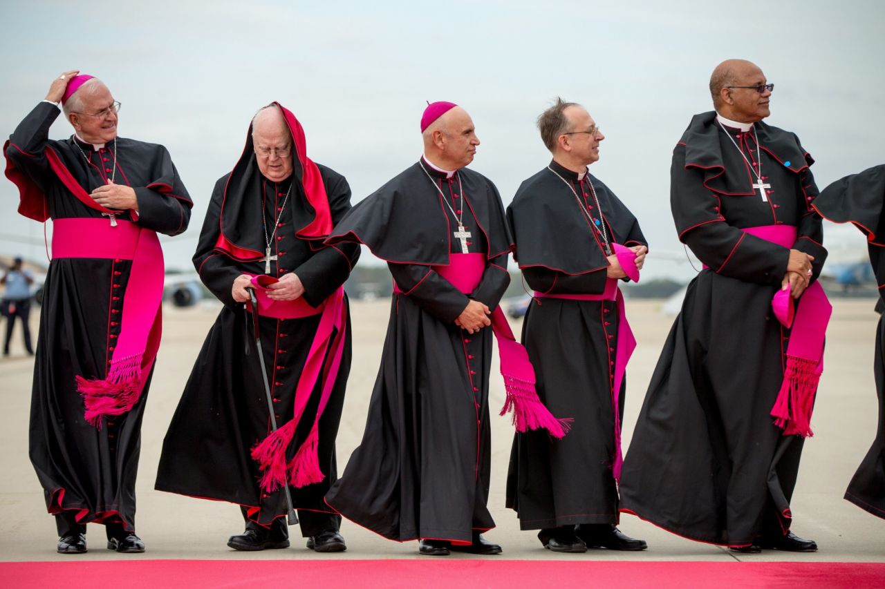 Clergy members brace for the wind as they stand on the tarmac at Andrews Air Force Base.