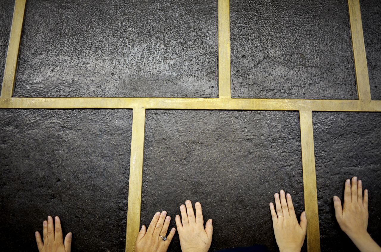 Muslim pilgrims touch Islam's holiest shrine, the <a href="https://www.khanacademy.org/humanities/art-islam/beginners-guide-islamic/a/the-kaaba" target="_blank" target="_blank">Kaaba</a>, at the Grand Mosque in Mecca on Monday, September 21. Performing the Hajj is one of the five pillars of Islam.