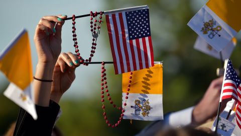 People wave U.S. and Vatican flags as they wait for the Pope's arrival at the White House on September 23.