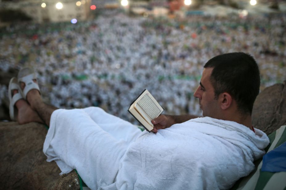 A pilgrim reads the Quran on a rocky hill called the Mountain of Mercy, on the plain of Arafat, near Mecca on Wednesday, September 23.
