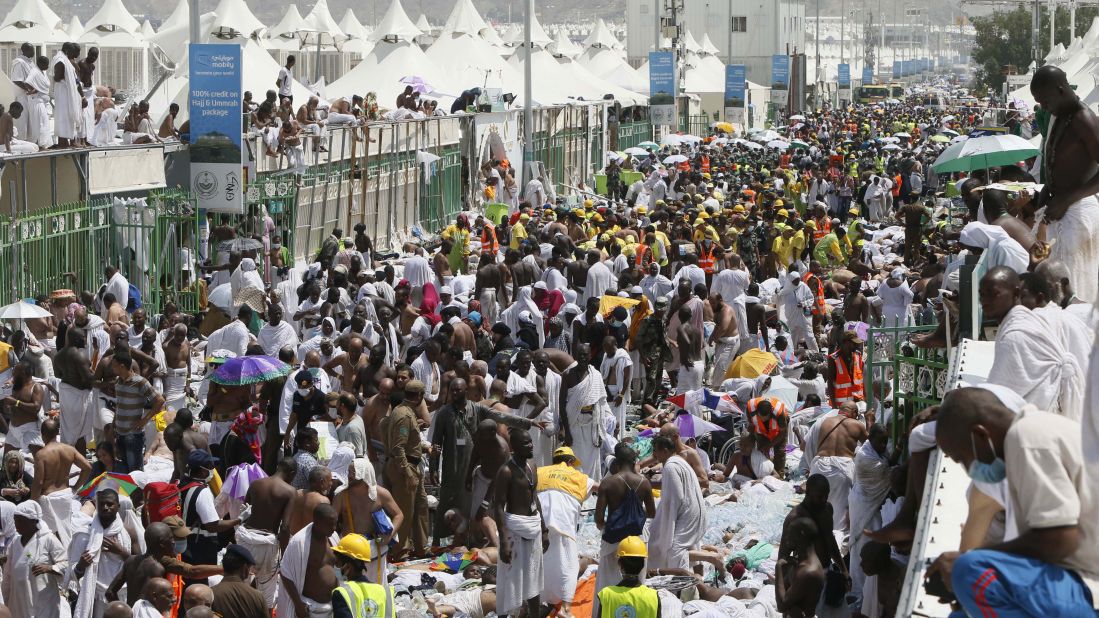 Muslim pilgrims and rescuers gather around the victims.