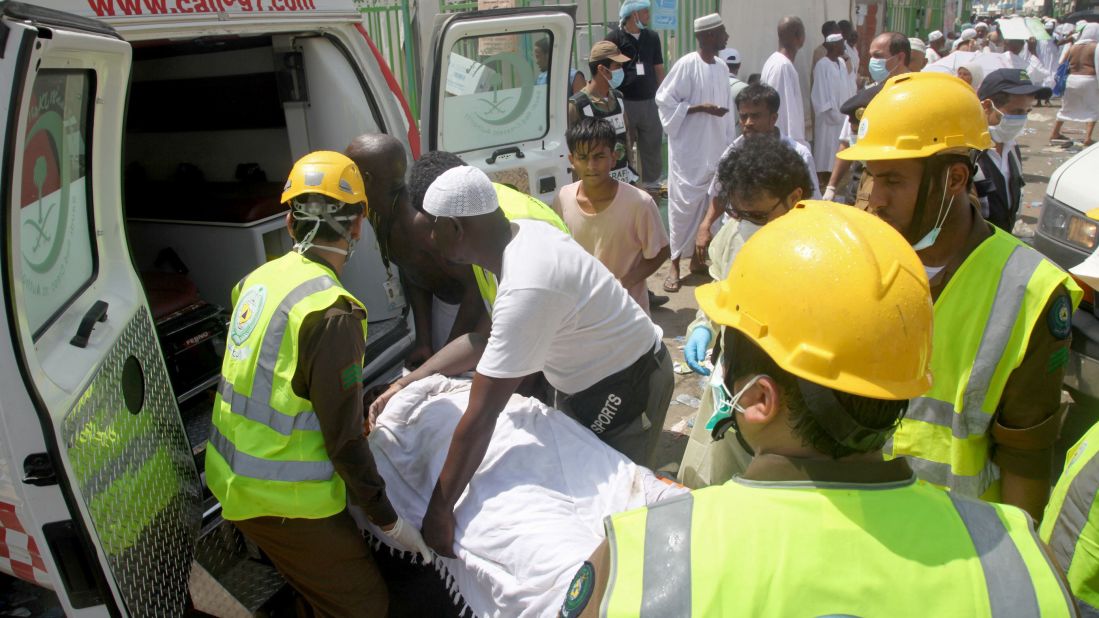 Saudi emergency personnel load a wounded pilgrim into an ambulance.