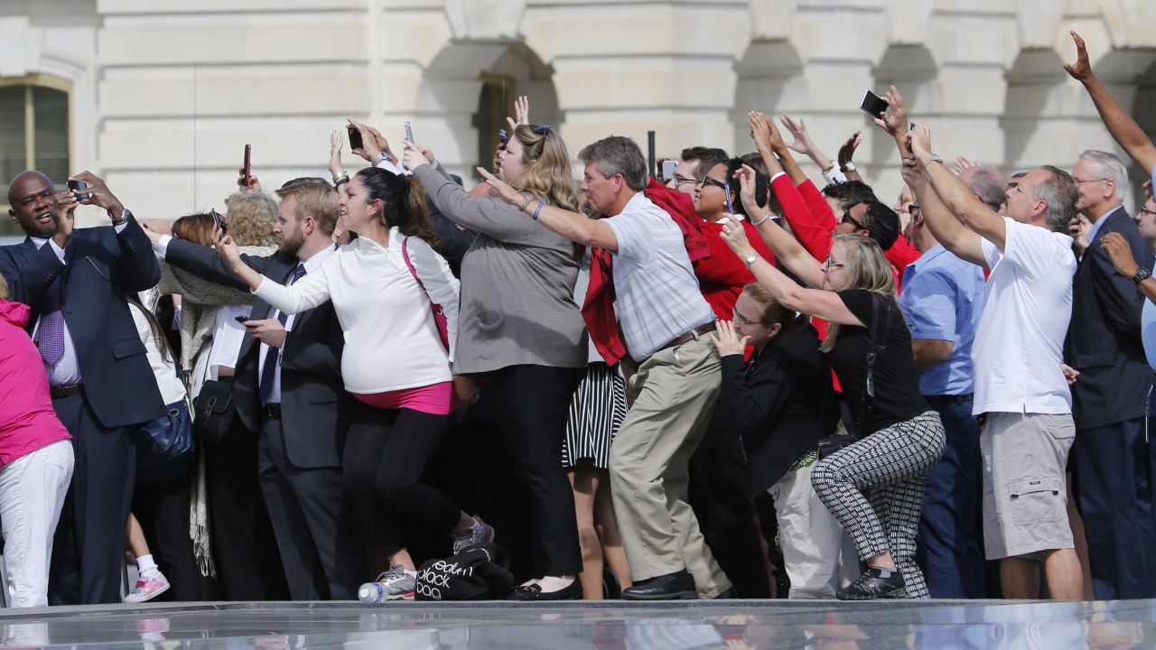 Congressional staffers and guests strain to view and photograph the Pope at the Capitol.
