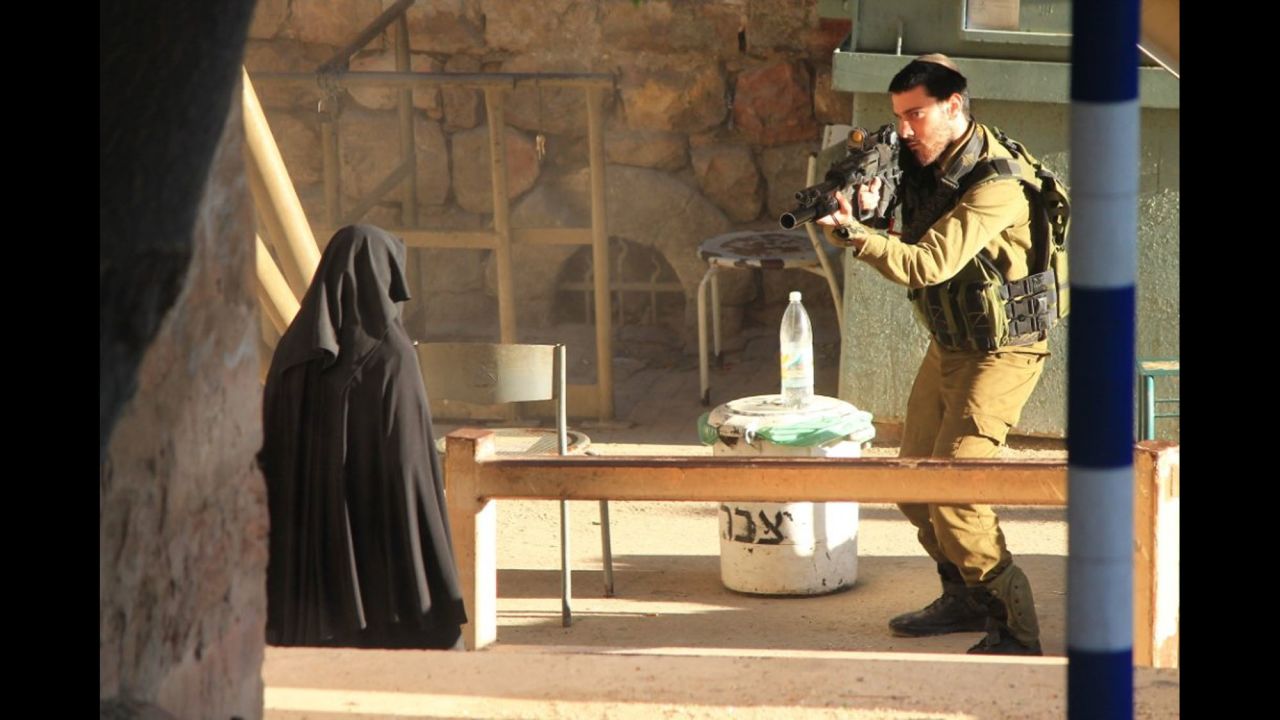 This photo from a Palestinian activist group is said to show an Israeli soldier and <a href="http://www.cnn.com/2015/09/23/middleeast/palestinian-shot-west-bank/" target="_blank">a teenager who was shot</a> at a military checkpoint in Hebron, West Bank, on Tuesday, September 22. Israel Defense Forces said a teenager was shot after she tried to stab an Israeli soldier, but a witness said she was surrounded by soldiers and was standing still when shot. CNN could not independently verify the teen's identity or the IDF's statement that a knife was recovered at the scene.