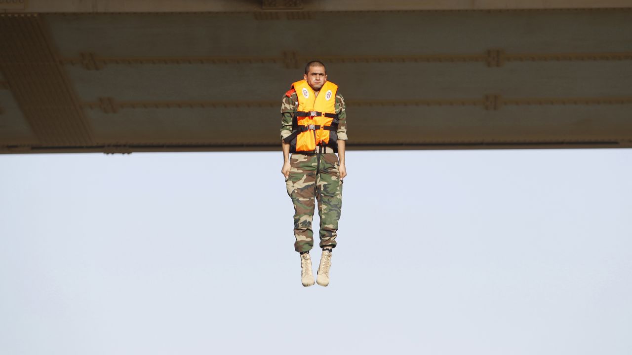 An Iraqi army cadet performs a "leap of faith" from a bridge in Baghdad on Tuesday, September 22.