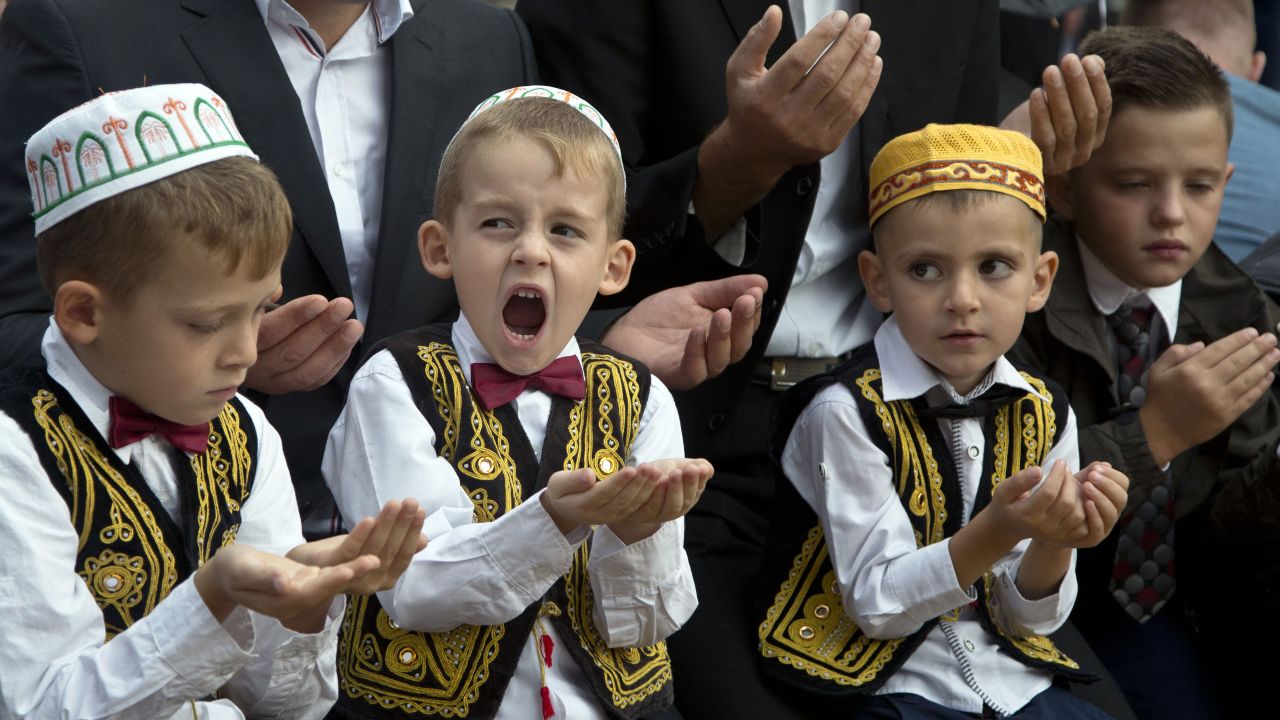 A boy yawns as he offers prayers outside a mosque in Pristina, Kosovo, on Thursday, September 24.