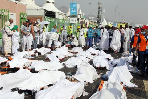 People stand near the bodies of victims at the site of the stampede.