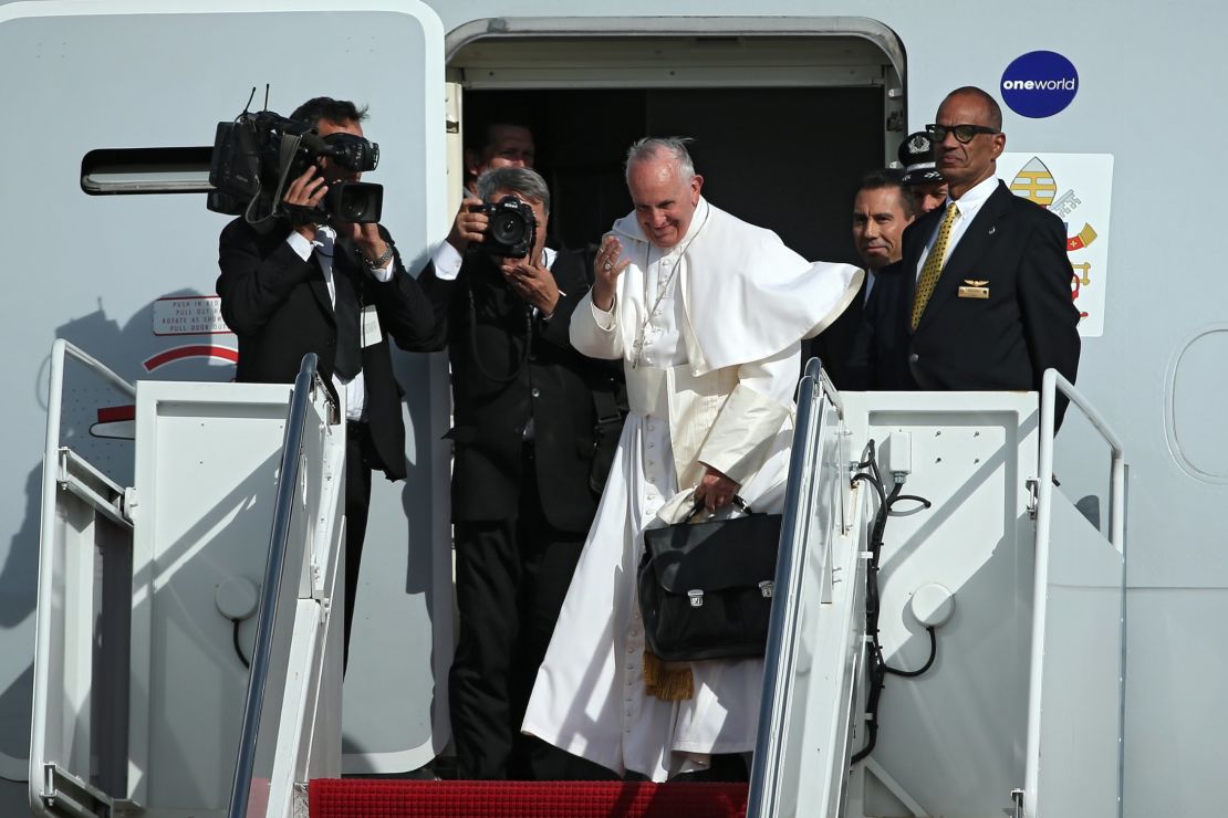 Pope Francis carries his bag off the plane.