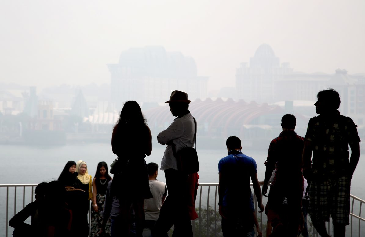 Thick air pollution has been choking parts of Indonesia, Singapore and Malaysia for weeks. People are silhouetted against Singapore's popular tourist destination, Sentosa, seen through the haze on September 24, 2015.