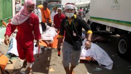 Saudi emergency personnel and Hajj pilgrims carry a wounded person at the site where at least 450 were killed and hundreds wounded in a stampede in Mina, near the holy city of Mecca, at the annual hajj in Saudi Arabia on September 24, 2015. The stampede, the second deadly accident to strike the pilgrims this year, broke out during the symbolic stoning of the devil ritual, the Saudi civil defence service said.