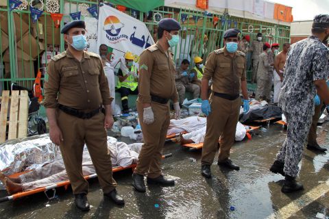 Saudi emergency personnel stand near bodies of Hajj pilgrims. 