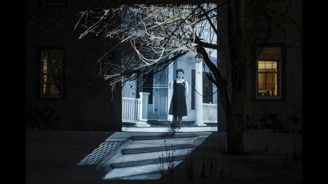 Leah Miriam Cooper collected old family photographs and projected them onto her home. She said the project helped her feel closer to the relatives she never really knew. Seen here is Cooper's paternal grandmother, Hannah, standing in front of her Nebraska home in 1943. The image was projected onto Cooper's Rhode Island home in February.