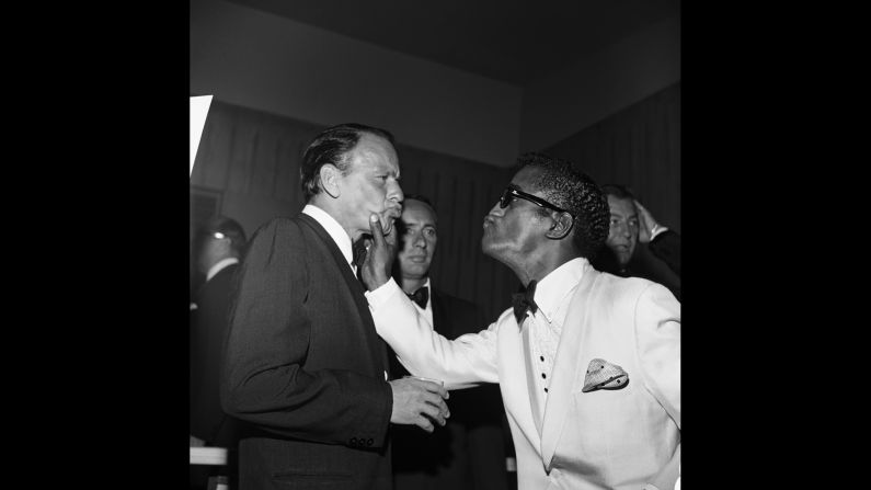Davis squeezes Sinatra's face in 1961 while comedian Joey Bishop, center, looks on.