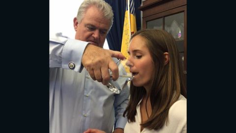 Rep. Bob Brady in his office sharing a glass of water previously used by Pope Francis with Staff Assistant Colleen Carlos.