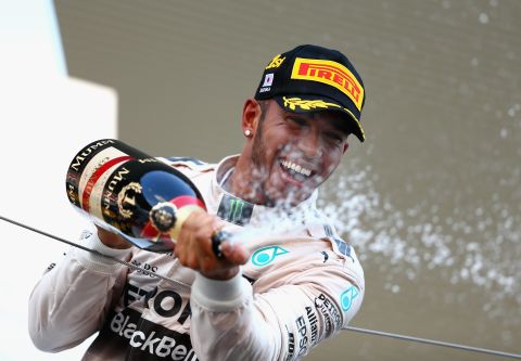 Hamilton celebrates on the podium after winning the Japanese Grand Prix at Suzuka to extend his title lead.