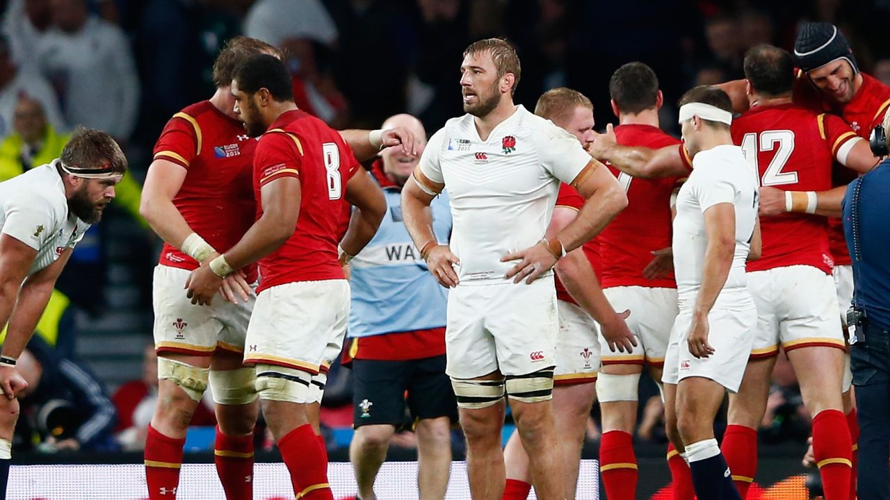 England captain Chris Robshaw cuts a dejected figure as Wales celebrates a famous win at Twickenham.