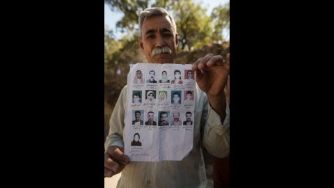 Jamil Jato shows photos of family members who were murdered by ISIS.