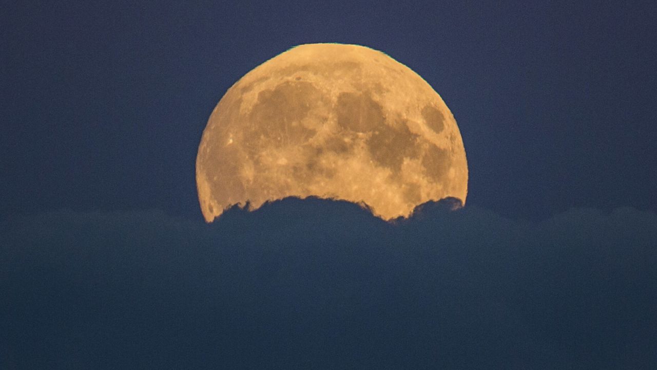 The supermoon rises from behind clouds in Berlin.