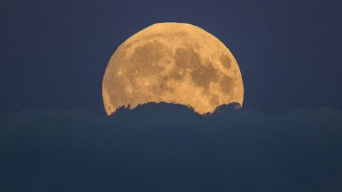 The supermoon rises from behind clouds in Berlin.