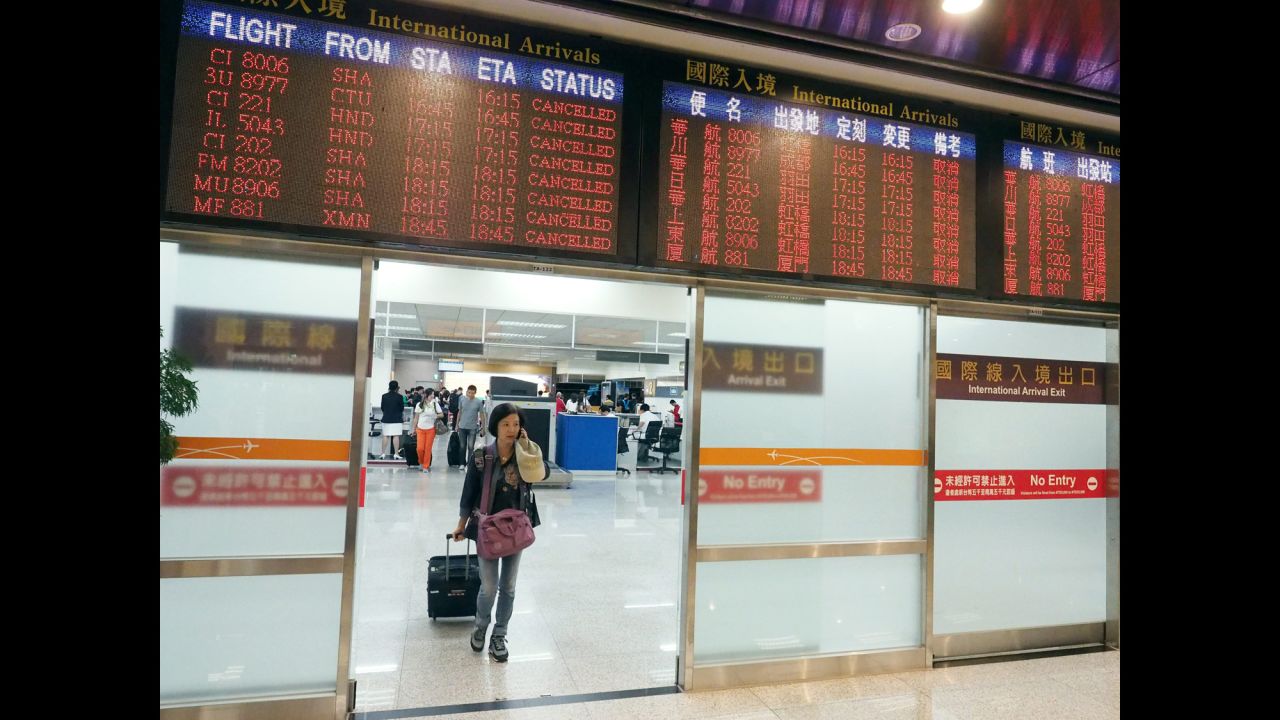 A passenger arrives at the Taipei Songshan Airport on September 28 as a flight information board shows canceled flights from China and Japan to Taipei.
