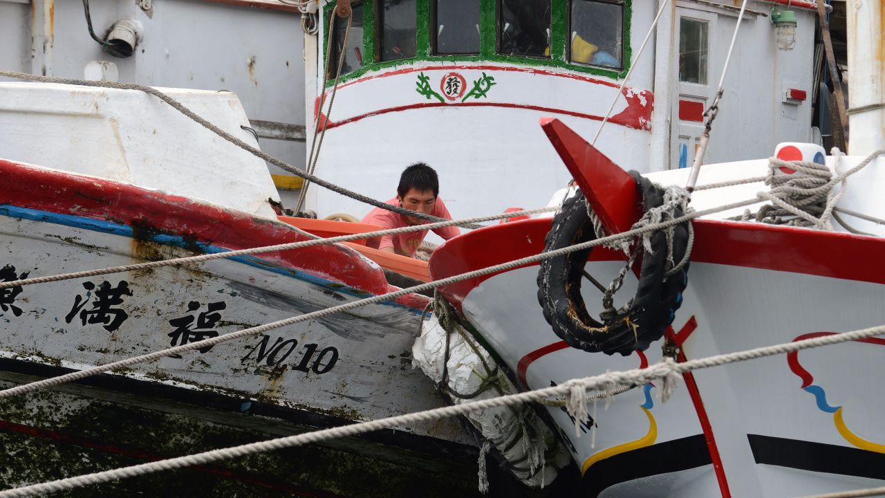 A fisherman works on a fishing boat near the coast of Keelung on September 28.