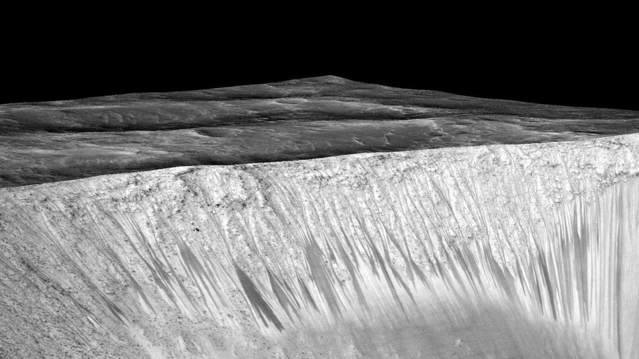 NASA says it found proof of water in dark streaks like these, called recurring slope lineae, on the walls of the Garni Crater on Mars.