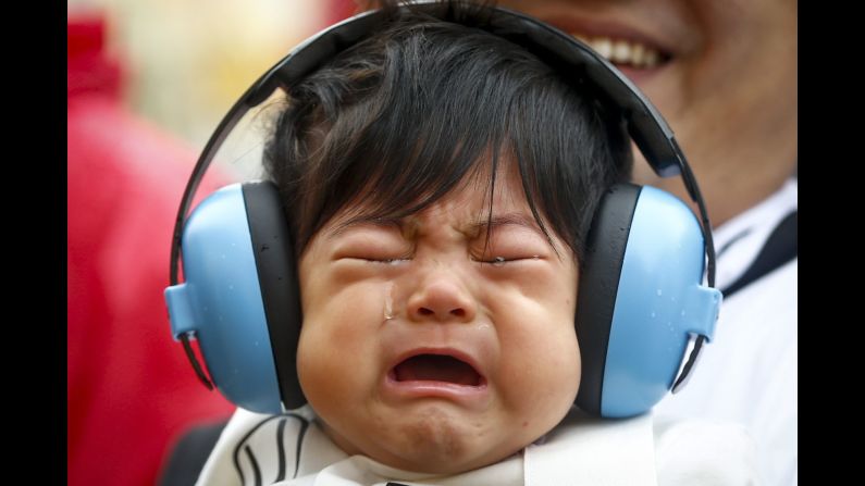 A 7-month-old boy cries as his father walks him near the Mercedes garage at the Suzuka track in Japan on Thursday, September 24. The track was hosting the latest Formula One race.