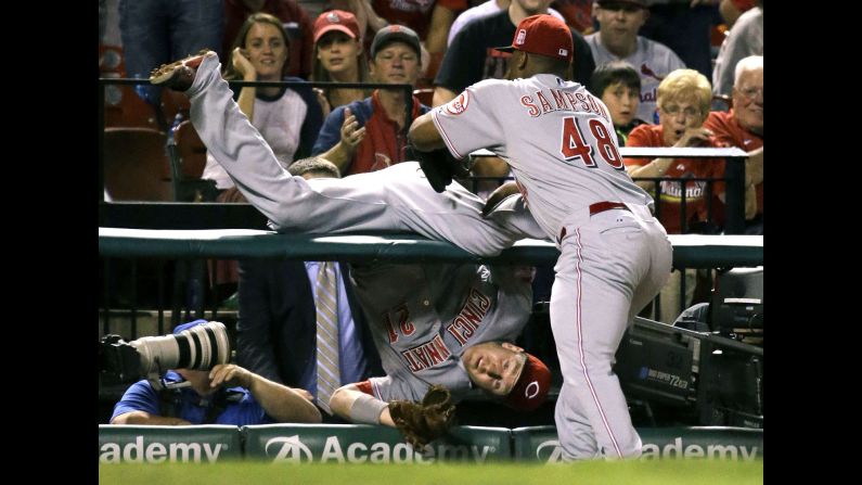 Cincinnati's Keyvius Sampson grabs teammate Todd Frazier after Frazier <a href="index.php?page=&url=http%3A%2F%2Fbleacherreport.com%2Farticles%2F2570947-reds-3b-todd-frazier-goes-over-railing-on-catch-p-keyvius-sampson-saves-him" target="_blank" target="_blank">flipped over a railing</a> while catching a foul ball Tuesday, September 22, in St. Louis.